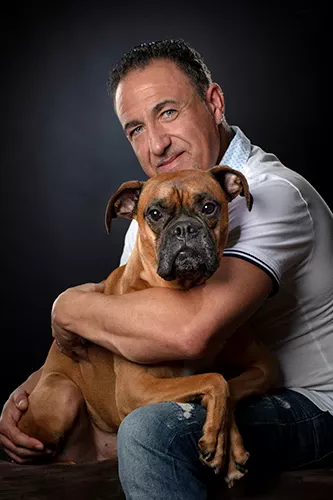 un homme et son chien dans les bras
