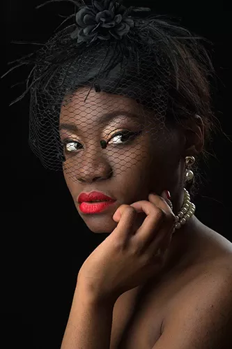 portrait d'une femme noire avec coiffe à plumes